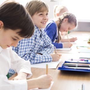 Happy kids writing an exam