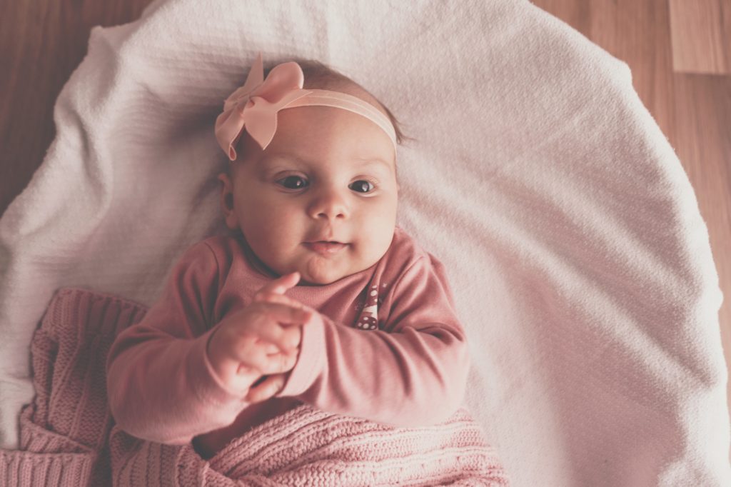 Little cute baby girl lying in basket