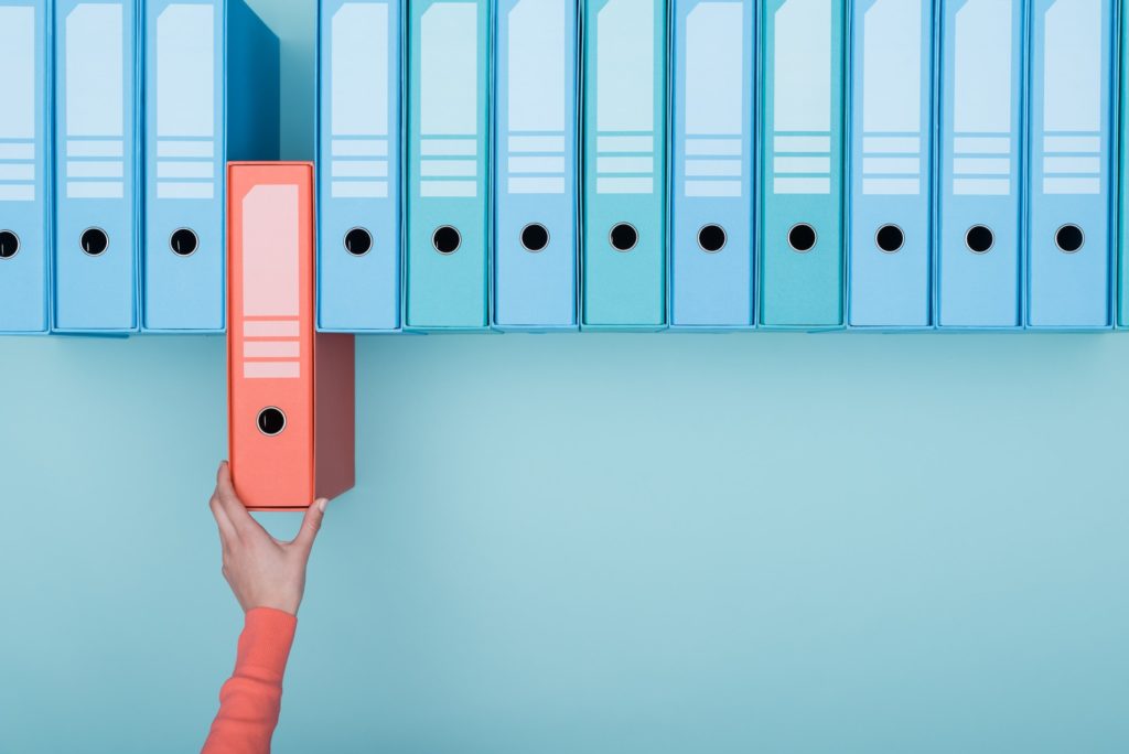 Office worker taking a folder in the archive