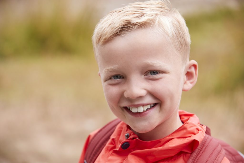 Portrait of pre-teen Caucasian boy outdoors, front view