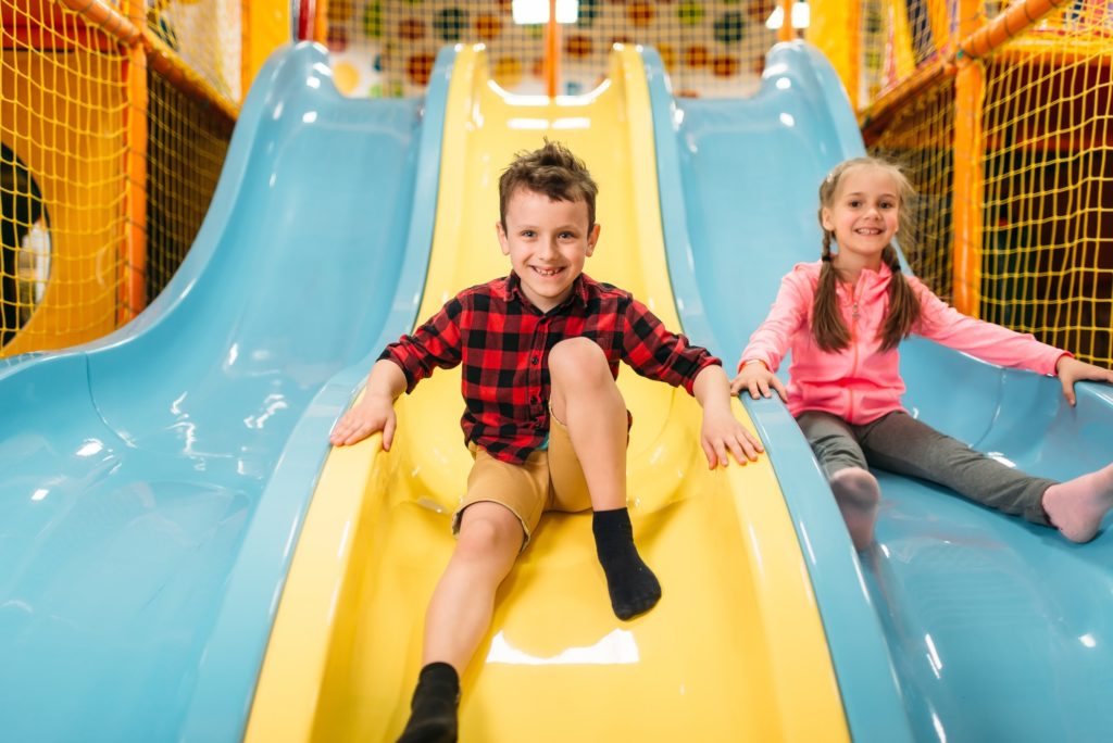 Kids riding from childrens slides in game center